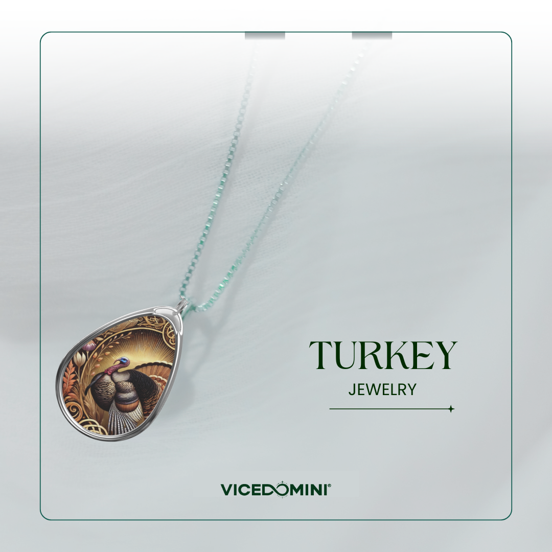 A Vicedomini jewelry necklace featuring a teardrop-shaped pendant with a detailed illustration of a turkey on a gold-toned background, suspended from a light mint-green chain. The pendant is displayed against a clean, light gray textured background with the text 'TURKEY JEWELRY' and the brand 'VICEDOMINI' printed on the right.