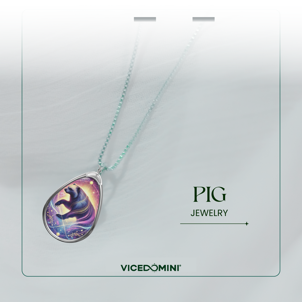 A Vicedomini Pig Jewelry necklace featuring a silver teardrop pendant with a colorful cosmic pig illustration, suspended on a light mint green chain against a white textured background with branding text.