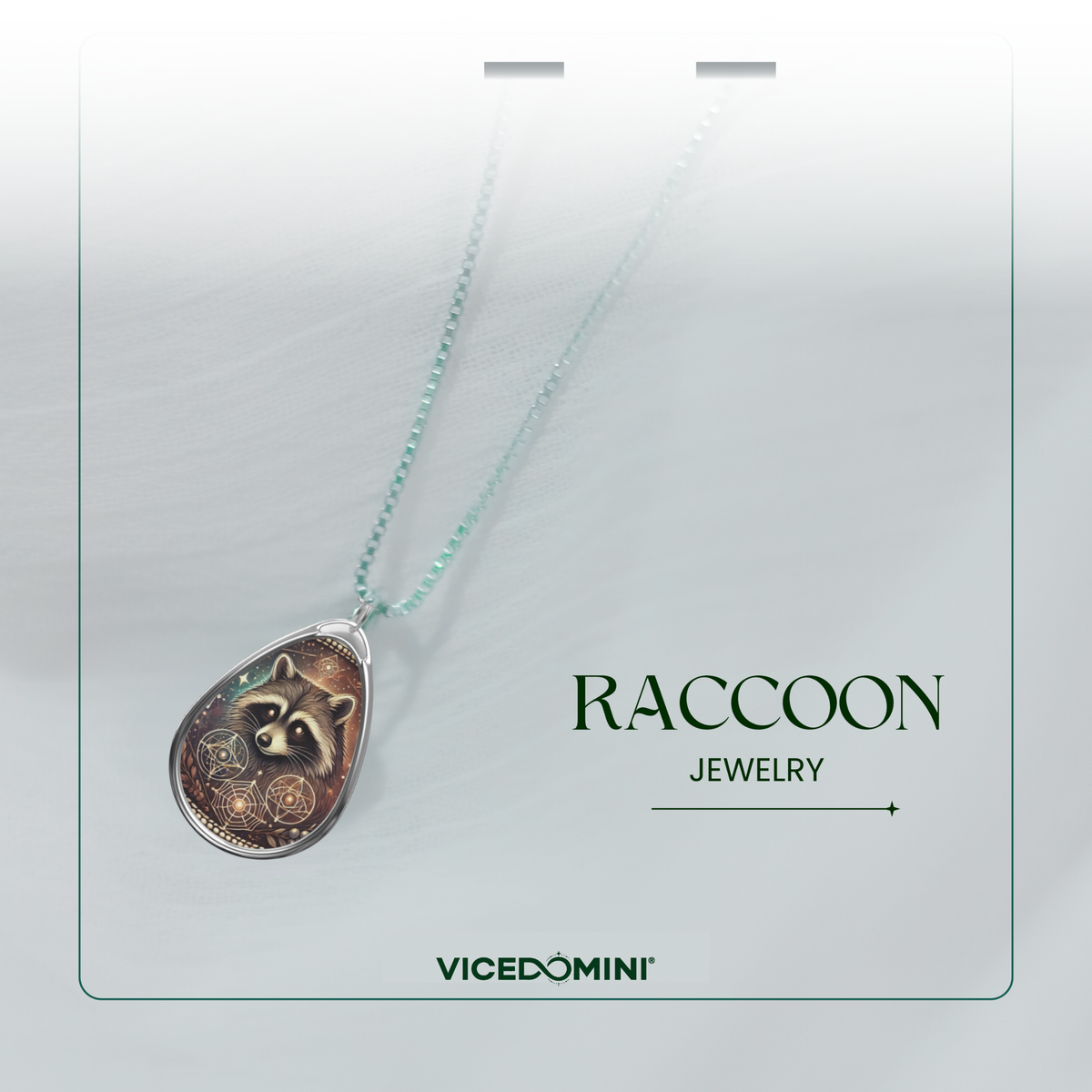 Close-up of a raccoon pendant necklace on a soft white fabric background, with the text 'RACCOON JEWELRY' and 'VICEDOMINI' placed beside it.
