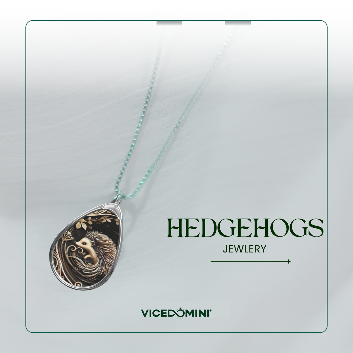 A teardrop-shaped pendant necklace with a detailed lion head design in dark metal, suspended from a light mint-green chain, presented on a light gray background with 'HEDGEHOGS JEWELRY' and 'VICEDOMINI' branding.
